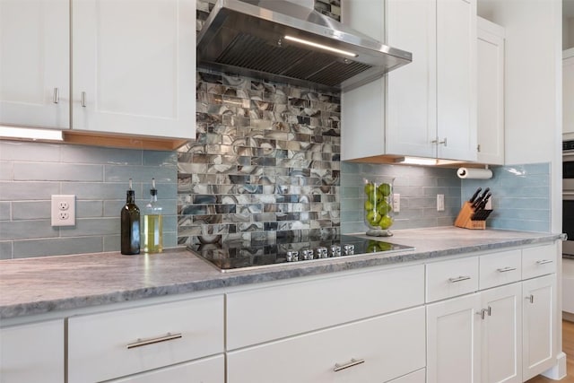 kitchen featuring white cabinets, wall chimney range hood, decorative backsplash, and black electric cooktop