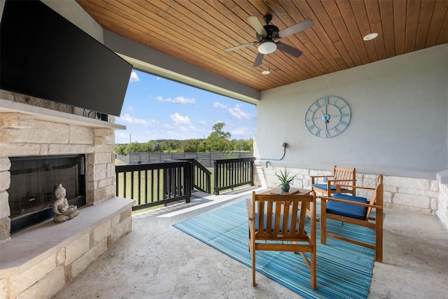 view of patio / terrace featuring a ceiling fan and an outdoor stone fireplace