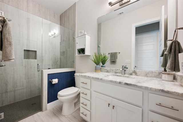 bathroom with toilet, a stall shower, visible vents, and vanity