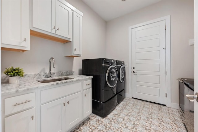 laundry area with cabinet space, baseboards, light floors, washing machine and dryer, and a sink