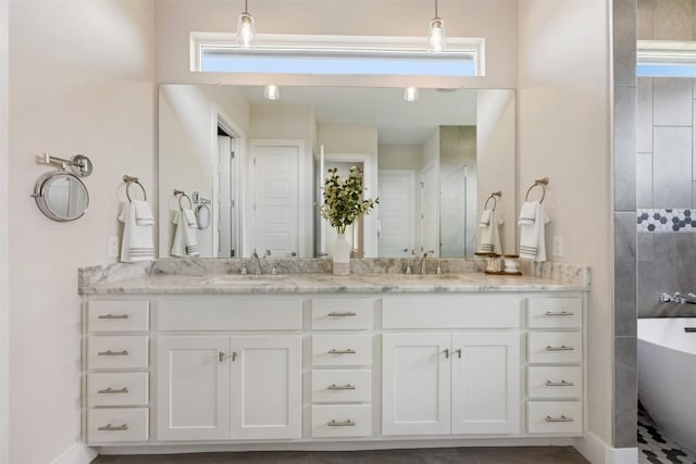 full bath with a healthy amount of sunlight, double vanity, a shower, and a sink