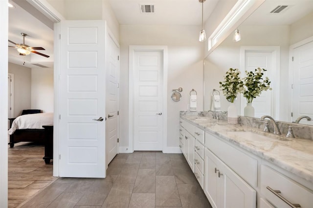 bathroom with ceiling fan, double vanity, a sink, and visible vents