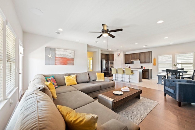 living room featuring recessed lighting, visible vents, ceiling fan, and light wood-style flooring