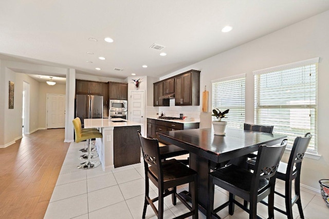 dining room with light tile patterned floors, baseboards, visible vents, and recessed lighting