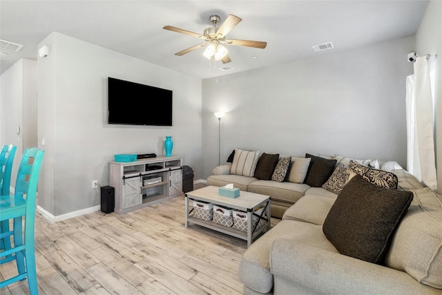 living area featuring visible vents, ceiling fan, baseboards, and wood finished floors