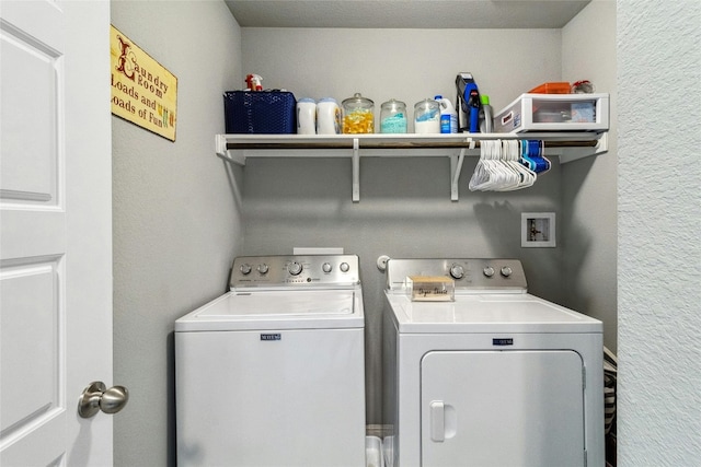 laundry area featuring a textured wall, laundry area, and washer and dryer