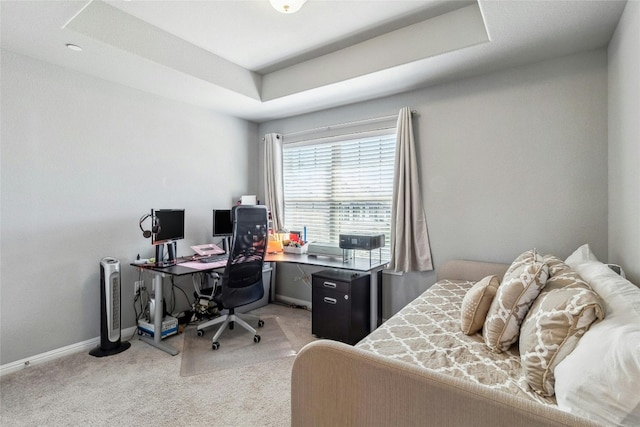 bedroom with light carpet, baseboards, and a raised ceiling