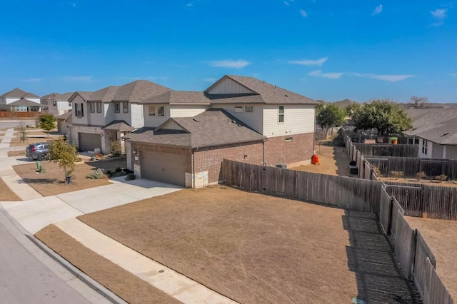 exterior space with a residential view, driveway, and fence