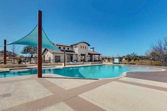 pool with a patio area and fence