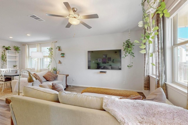 living area with recessed lighting, visible vents, a ceiling fan, wood finished floors, and baseboards