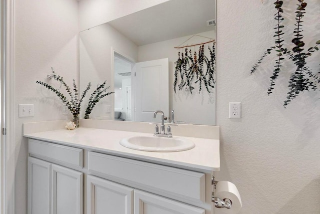 bathroom featuring a textured wall and vanity