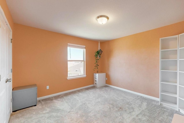 empty room featuring carpet flooring and baseboards