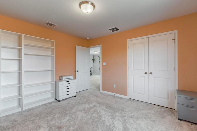 unfurnished bedroom featuring carpet floors, baseboards, visible vents, and a closet