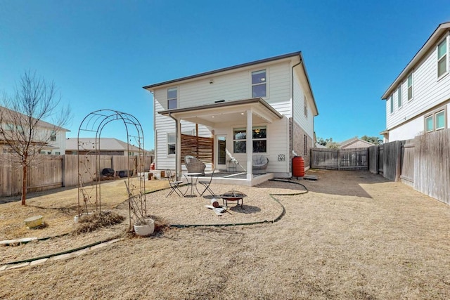 rear view of house featuring an outdoor fire pit, a patio area, and a fenced backyard