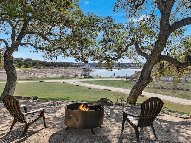 view of patio / terrace featuring a water view and an outdoor fire pit