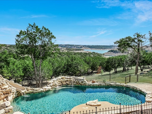 view of pool with a fenced in pool, fence, and a water slide