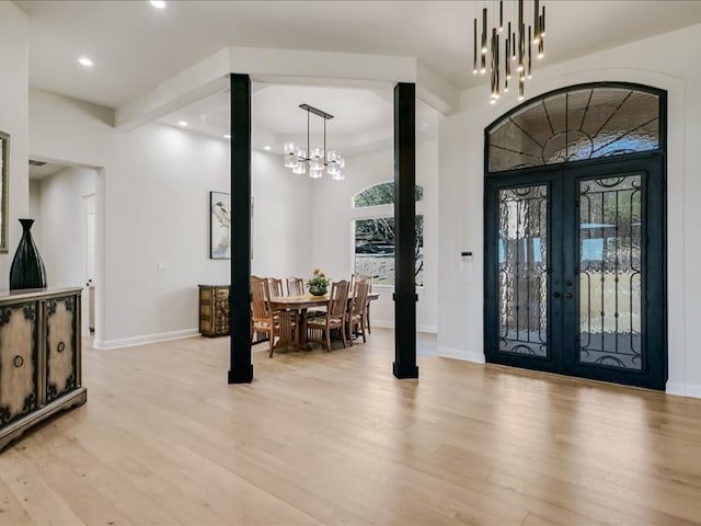 foyer with light wood-style flooring, recessed lighting, baseboards, french doors, and an inviting chandelier