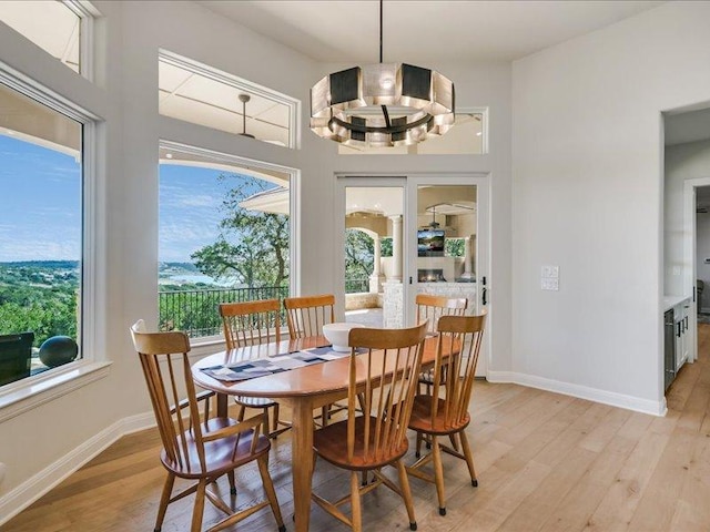 dining area with a chandelier, light wood-type flooring, and baseboards