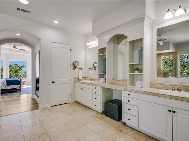 ensuite bathroom with a healthy amount of sunlight, vanity, visible vents, and a ceiling fan