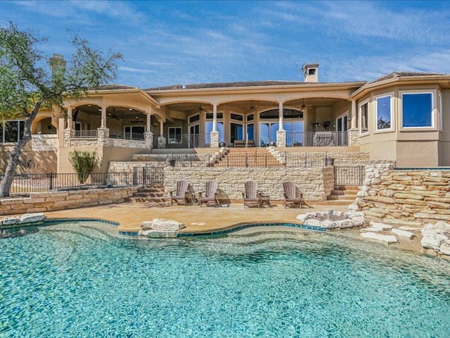 view of pool featuring ceiling fan, a patio, fence, stairway, and a fenced in pool