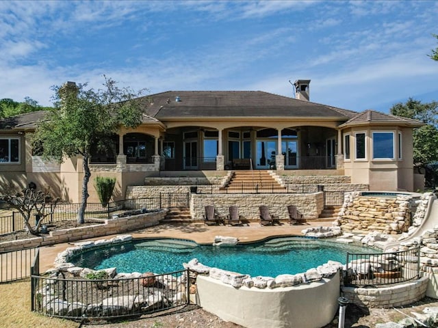 back of property featuring stucco siding, stairway, a hot tub, a patio area, and fence