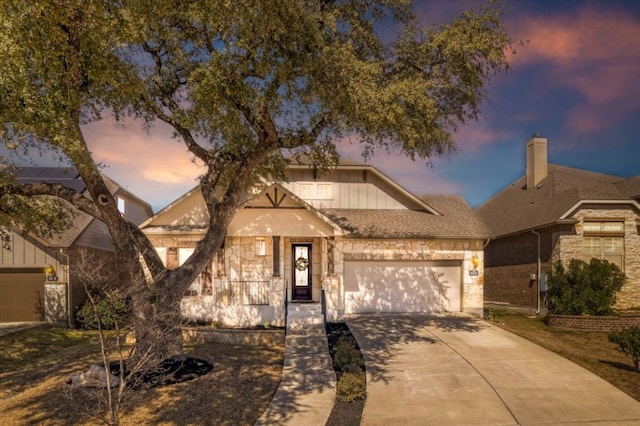 view of front of property featuring stone siding, concrete driveway, board and batten siding, and an attached garage