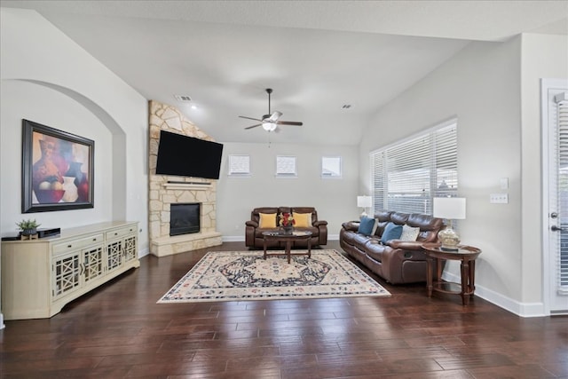 living room with lofted ceiling, visible vents, wood finished floors, and a stone fireplace