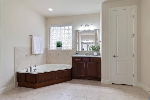 bathroom with a garden tub, tile patterned floors, and vanity