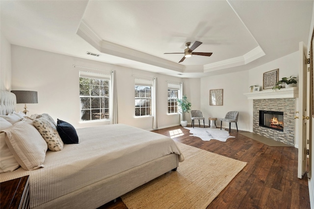 bedroom with visible vents, a raised ceiling, hardwood / wood-style floors, and ornamental molding