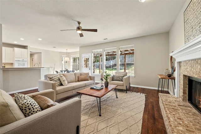 living room with baseboards, a ceiling fan, wood finished floors, a fireplace, and recessed lighting