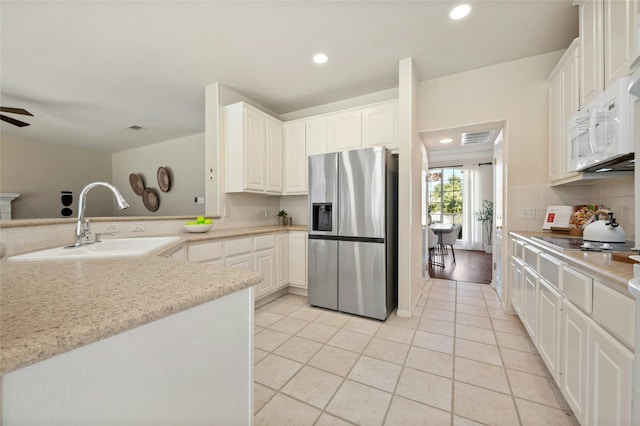 kitchen with stainless steel fridge, a sink, decorative backsplash, and black electric cooktop