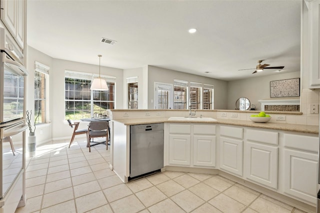 kitchen with visible vents, stainless steel dishwasher, white cabinetry, a sink, and light tile patterned flooring