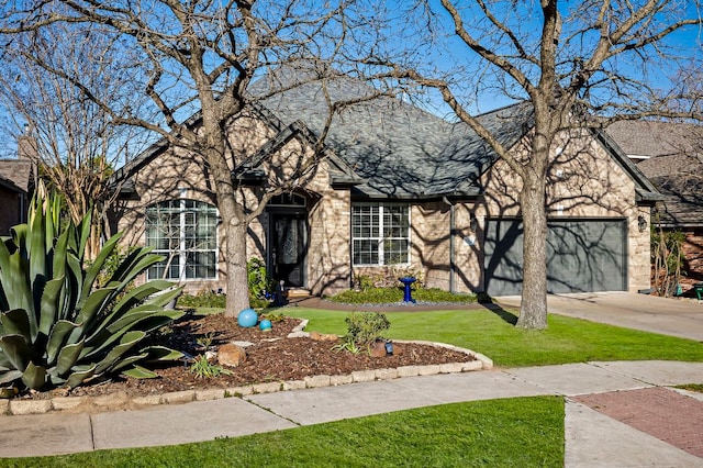 view of front of property featuring a garage, brick siding, concrete driveway, roof with shingles, and a front yard