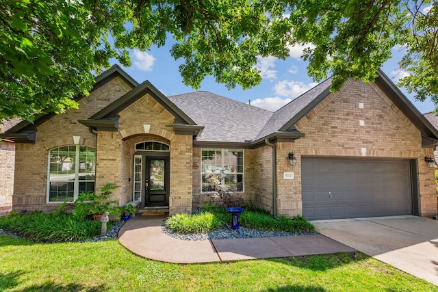 5312 Fort Benton Dr, Austin, TX 78735 - view of front of house featuring brick siding, an attached garage, concrete driveway, a front yard, and a shingled roof