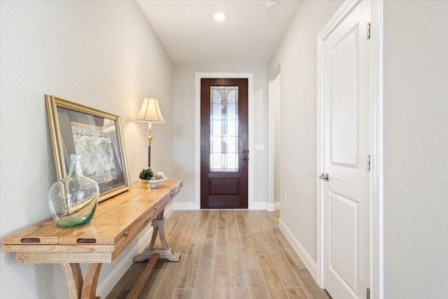 doorway featuring light wood-style floors and baseboards