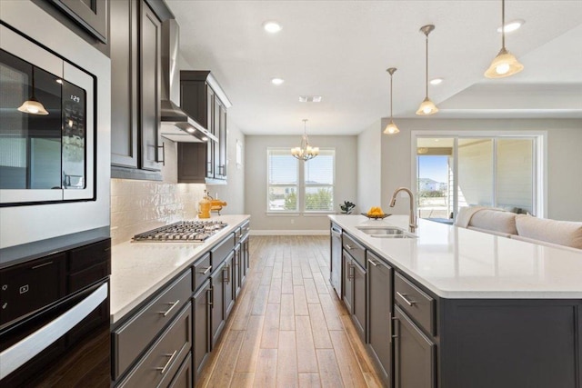 kitchen with light wood-style flooring, a sink, visible vents, appliances with stainless steel finishes, and tasteful backsplash