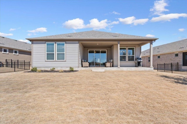 rear view of property featuring a patio area, a fenced backyard, and a lawn