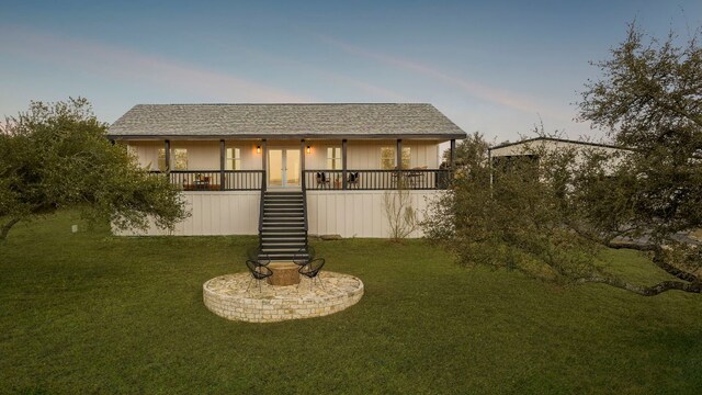 200 Hilltop Dr, Dripping Springs, TX 78620 - back of house at dusk featuring stairs, a yard, board and batten siding, a shingled roof, and french doors
