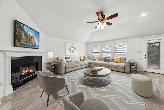 701 Portchester Castle Path, Pflugerville, TX 78660 - living area featuring vaulted ceiling, a glass covered fireplace, ceiling fan, wood finished floors, and recessed lighting