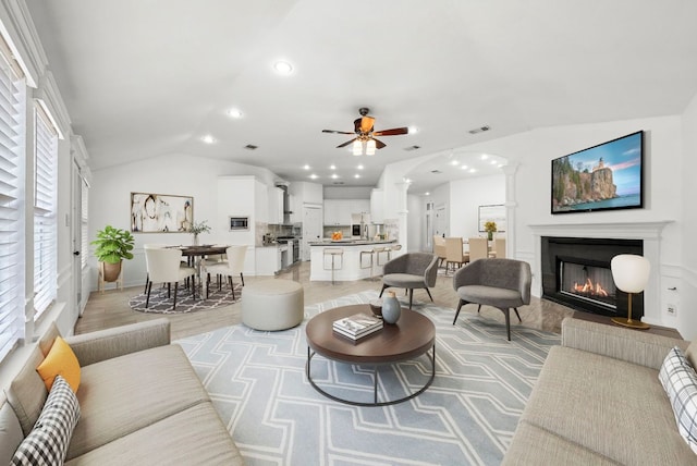 701 Portchester Castle Path, Pflugerville, TX 78660 - living area with lofted ceiling, a glass covered fireplace, recessed lighting, ceiling fan, and arched walkways