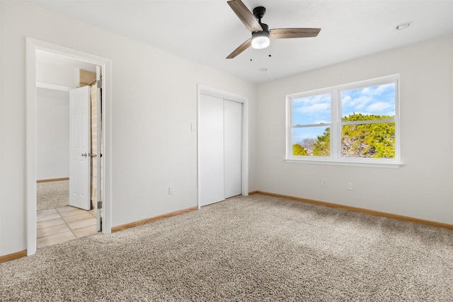 unfurnished bedroom featuring carpet floors, a ceiling fan, baseboards, and a closet