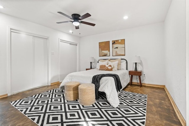 bedroom with baseboards, recessed lighting, two closets, and finished concrete floors