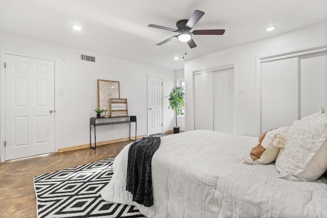 bedroom with baseboards, visible vents, ceiling fan, two closets, and recessed lighting