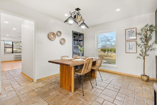 dining space with baseboards, an AC wall unit, recessed lighting, and a healthy amount of sunlight