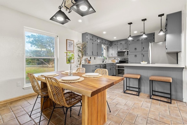 dining area with baseboards, recessed lighting, and stone tile floors