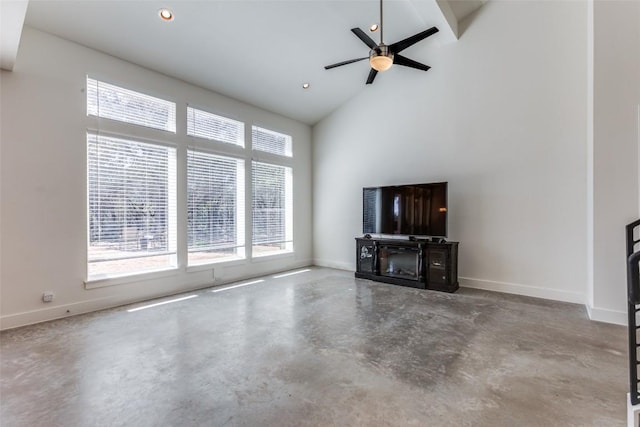 unfurnished living room featuring finished concrete flooring, baseboards, and high vaulted ceiling