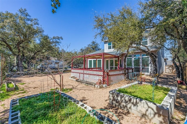 exterior space with a garden, fence, and a wooden deck