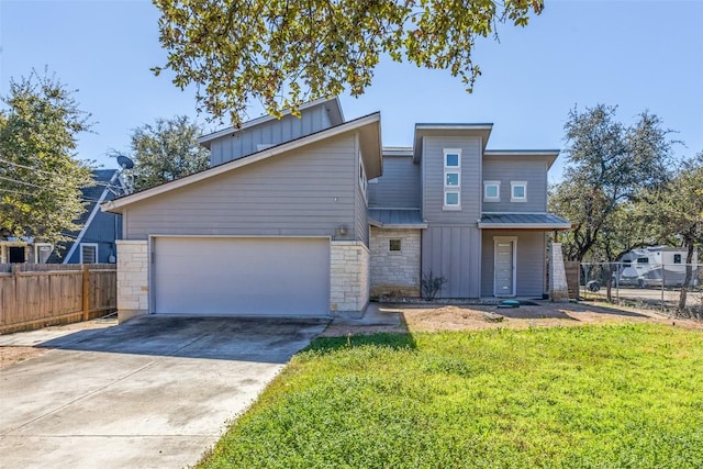 14805 Foy Dr, Austin, TX 78734 - view of front of home with a metal roof, concrete driveway, an attached garage, board and batten siding, and stone siding