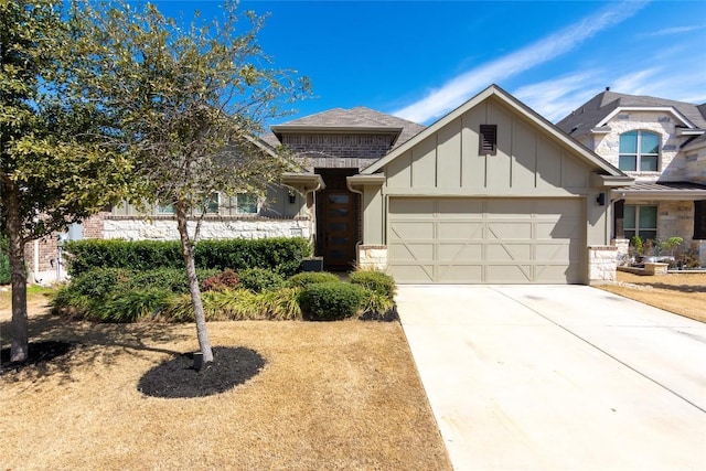 view of front facade featuring a garage, stone siding, board and batten siding, and concrete driveway