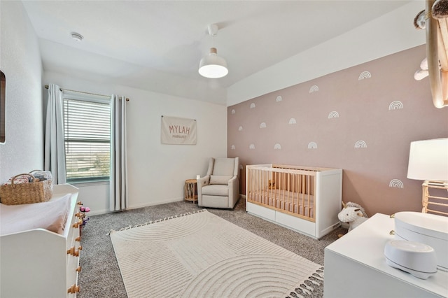 bedroom with carpet floors, a nursery area, and baseboards